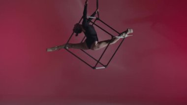 Modern koreografi ve akrobasi yaratıcı reklam konsepti. Renkli arka planda kadın akrobatın portresi. Kadın akrobatlar yüksek topuklularla havada iplerle poz veriyorlar.