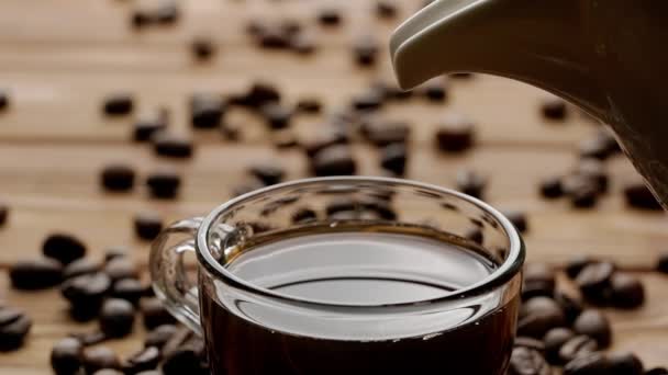 ピッチャーからコーヒーカップにミルクの流れが流れ込み そこに溶け込む キッチンテーブルのグラスコーヒーまたはティーカップを閉じます 朝の儀式 朝食のコンセプト スローモーション — ストック動画