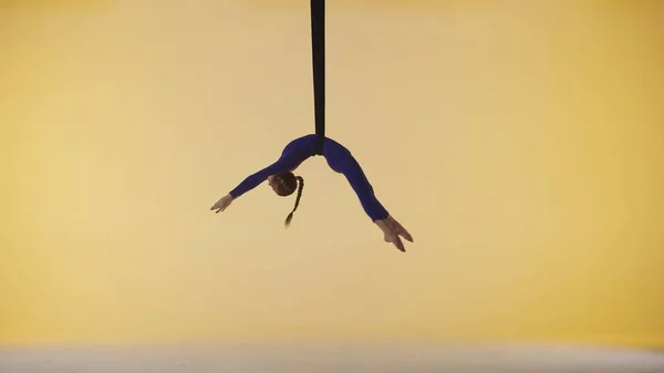 现代编舞和杂技创意广告的概念 女体操运动员被隔离在黄色的工作室背景下 在体操带上旋转的女空中舞者 表现出杂技元素 — 图库照片