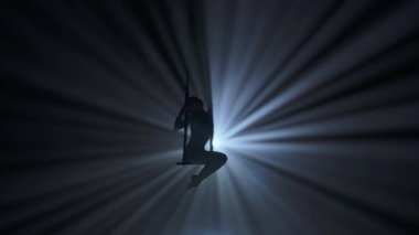 Modern koreografi ve akrobasi yaratıcı reklam konsepti. Kadın jimnastikçi siyah arka plan ışıkları ve dumanında izole edilmiş. Kız hava dansçısı trapezde kayışlarla akrobatik öğeler gösteriyor.