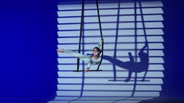 现代编舞和杂技创意广告的概念 女体操运动员被隔离在蓝色霓虹灯工作室的背景下 女子空中舞蹈演员手握和旋转着带有带子的杂技特技表演 — 图库视频影像