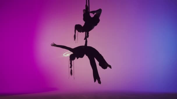现代编舞和杂技创意广告的概念 女子体操双人隔离在激光粉红霓虹灯演播室背景 女子空中舞蹈演员在带背带的体操圈上保持平衡 — 图库视频影像
