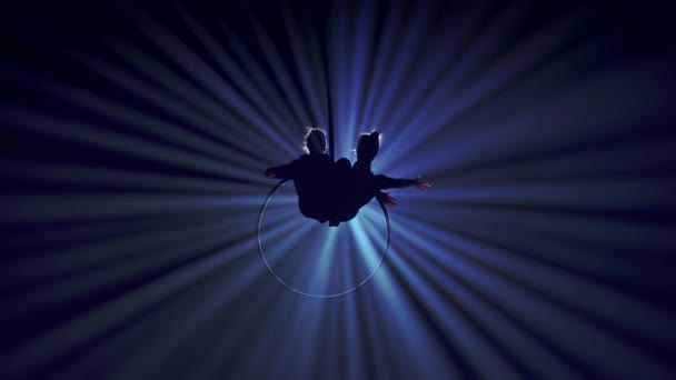 現代の振付とアクロバットクリエイティブ広告コンセプト スポットライトと煙で黒い背景に隔離された2人の女性ジムナスト ストラップ付きリング上の要素を示す少女空中ダンサー — ストック動画