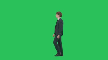 Modern iş adamı yaratıcı reklam konsepti. Krom anahtar yeşil ekran arka planında izole edilmiş takım elbiseli erkek modelin profil görüntüsü. Mavi takım elbiseli pozitif genç işadamı yürüyor.