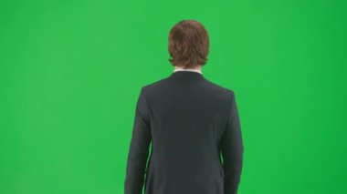 Modern iş adamı yaratıcı reklam konsepti. Krom anahtar yeşil ekranda izole edilmiş takım elbiseli erkek model. Mavi takım elbiseli pozitif genç işadamı yürüyor.
