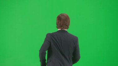 Modern iş adamı yaratıcı reklam konsepti. Krom anahtar yeşil ekranda izole edilmiş takım elbiseli erkek model. Mavi takım elbiseli genç iş adamı hızlı koşuyor..