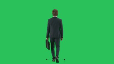 Modern iş adamı yaratıcı reklam konsepti. Krom anahtar yeşil ekranda izole edilmiş takım elbiseli erkek modelin arka planı. Takım elbiseli genç bir işadamı elinde evrak çantasıyla yürüyor..
