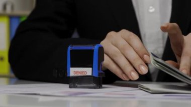 Pasaport ve göç yaratıcı reklam konsepti. Vize başvuru belgesinin yakın çekimi. Kadın çalışanın vurulması Ukrayna pasaportunu kontrol etmek, üzerinde imzası olmayan pullar koymak..
