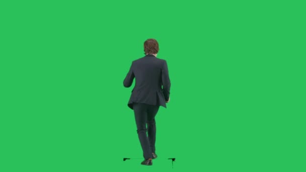 現代のビジネスマンクリエイティブ広告コンセプト クロマキーの緑色の背景に隔離されたスーツの男性モデルの背部ショット 面白い動きを示すウォーキングスーツの若いビジネスマンオフィスワーカー — ストック動画