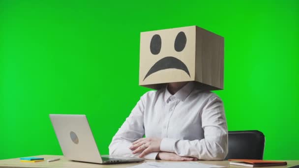 Vrouw Kartonnen Doos Met Negatieve Emoji Haar Hoofd Groene Studioachtergrond — Stockvideo