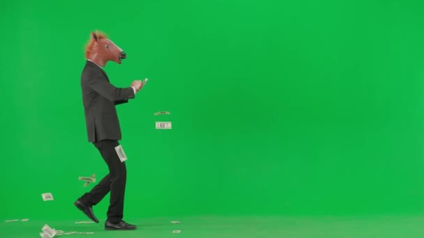 Egy Férfi Öltönyben Lófejmaszkkal Zöld Stúdió Háttérben Üzletember Boldogan Szórja — Stock videók