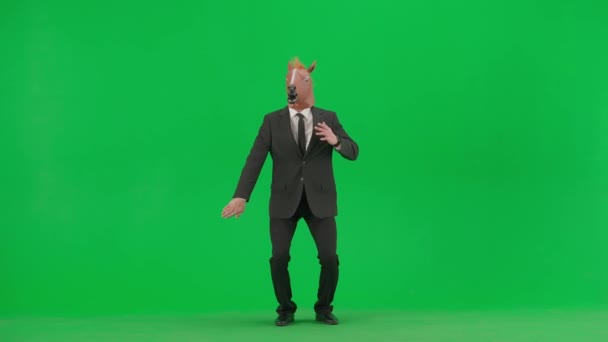 Egy Férfi Öltönyben Lófejmaszkkal Zöld Stúdió Háttérben Üzletember Vidáman Táncol — Stock videók