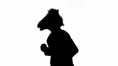 Beyaz izole edilmiş stüdyo arka planında at başlı maskeli iş adamı silueti. İş adamı hızlı koşuyor. Sıkı ofis işi kavramı