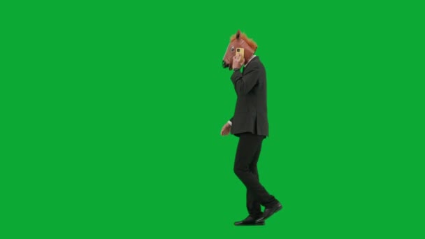 Mężczyzna Garniturze Końską Maską Zielonym Tle Studia Biznesmen Chodzący Mówiący — Wideo stockowe