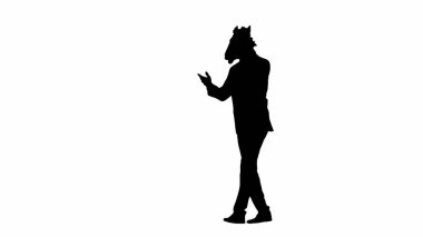 Beyaz izole edilmiş stüdyo arka planında at başlı maskeli iş adamı silueti. İş adamı akıllı telefondan konuşuyor ve yürüyor. Sıkı ofis işi kavramı