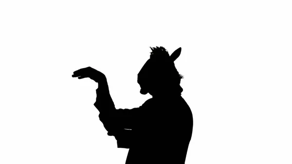 Black silhouette of man in business suit with horse head mask on white isolated studio background. Businessman dancing merrily. Concept of hard office work