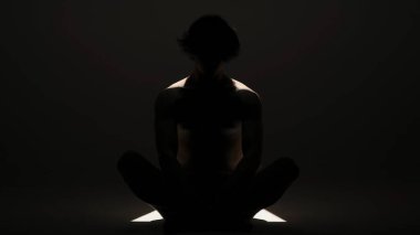 Vücut güzelliği ve sağlık hizmetleri yaratıcı reklam konsepti stüdyoda siyah arka planda erkek modelin portresi. Çekici bir adam silueti kameranın önünde poz veriyor..