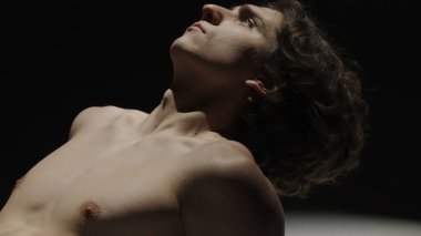 Vücut güzelliği ve sağlık hizmetleri yaratıcı reklam konsepti stüdyoda siyah arka planda erkek modelin portresi. Çekici adam silueti kameraya poz veriyor, kapat..