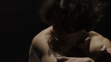 Vücut güzelliği ve sağlık hizmetleri yaratıcı reklam konsepti stüdyoda siyah arka planda erkek modelin portresi. Çekici bir adam silueti kameraya yan bakıyor..