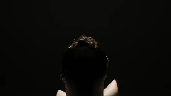 ボディビューティー ヘルスケアクリエイティブ広告コンセプト スポットライトの下に黒い背景にスタジオで男性モデルの肖像画 カメラで暗闇にポーズする魅力的な男のシルエット — ストック写真