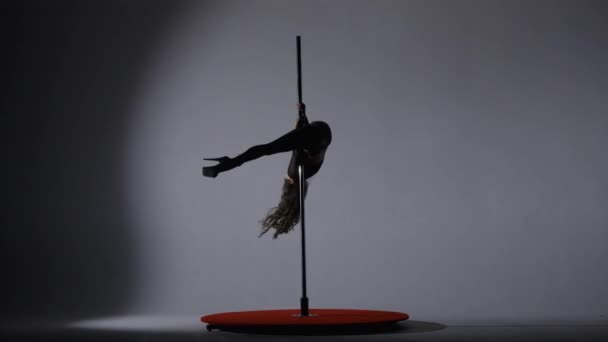 撑杆跳田径女舞蹈家在杆子上表演壮观的戏法 在聚光灯下的黑暗工作室里 一个优雅的女孩在塔楼上表演杂技 — 图库视频影像