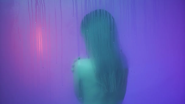 美容美感创意广告理念 在玻璃窗后面的霓虹灯下的女性画像 在蒸汽和水滴中 背对着相机 摸着皮肤 — 图库视频影像