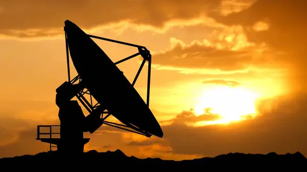 Modern industrial radio technology advertisement concept. Silhouette of one radar antenna over the sunset sky. Large modern satellite station telescope in the desert catching signals data.