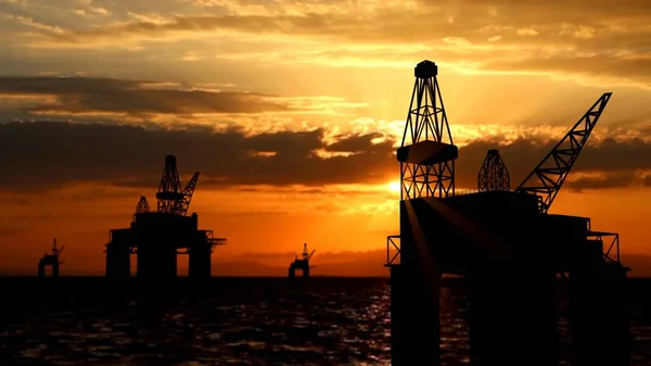 Modern technology of power industry creative advertisement concept. Shot of offshore oil platforms in the water over sunset sky. Large drilling oilfields with cranes extracting crude oil in the sea.