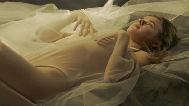 Naturalna Kobieta Leżąca Plecach Pokryta Białą Przezroczystą Tkaniną Świetle Słonecznym — Wideo stockowe