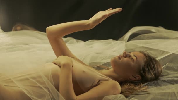 Atrakcyjna Młoda Kobieta Leżąca Plecach Białej Tkaninie Siatkowej Badająca Dłoń — Wideo stockowe