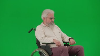 Emeklilerin bakımı ve günlük yaratıcı reklam konsepti. Krom anahtar yeşil ekranda sakat bir adamın portresi. Tekerlekli sandalyedeki kıdemli adam, genç kız bakıcı asistanını bekliyor..