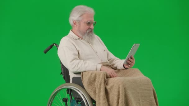 养恤金领取者照料和日常生活创意广告概念 彩色键绿色屏幕上的老年残疾人画像 坐在轮椅上的老人被平板电脑上的对话视频通话所覆盖 — 图库视频影像