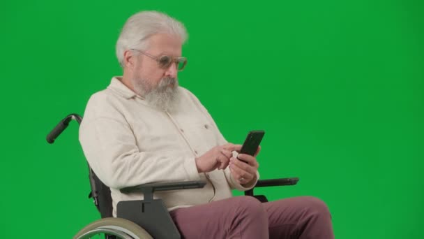 养恤金领取者照料和日常生活创意广告概念 彩色键绿色屏幕上的老年残疾人画像 坐在轮椅上的老人坐在智能手机的冲浪网上 — 图库视频影像