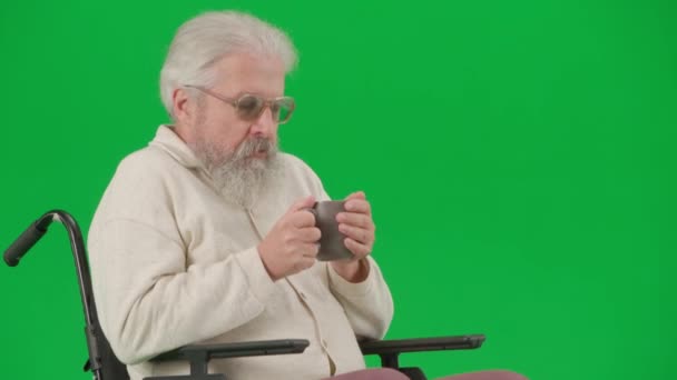 养恤金领取者照料和日常生活创意广告概念 彩色键绿色屏幕上的老年残疾人画像 亲近坐在轮椅上的老人 喝着热茶 感到冷 — 图库视频影像