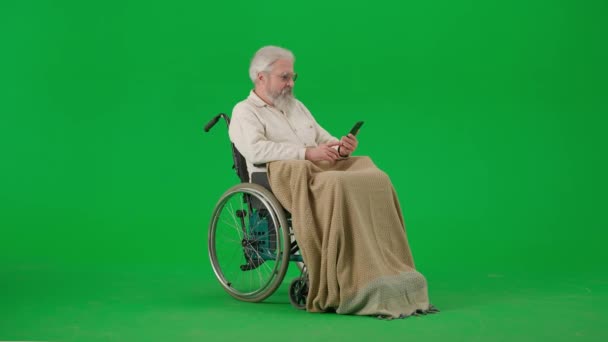 养恤金领取者照料和日常生活创意广告概念 彩色键绿色屏幕上的老年残疾人画像 坐在轮椅上的老人坐在智能手机上聊天视频通话 — 图库视频影像