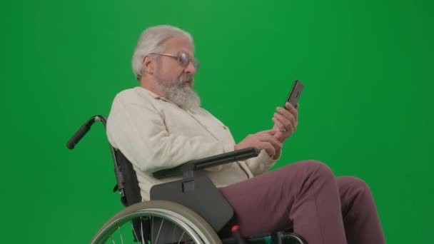 养恤金领取者照料和日常生活创意广告概念 彩色键绿色屏幕上的老年残疾人画像 坐在轮椅上的老年人在智能手机上通过视频通话 — 图库视频影像