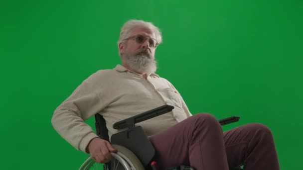 养恤金领取者照料和日常生活创意广告概念 彩色键绿色屏幕上的老年残疾人画像 坐在轮椅上的老人把镜头从车轮上移开 — 图库视频影像