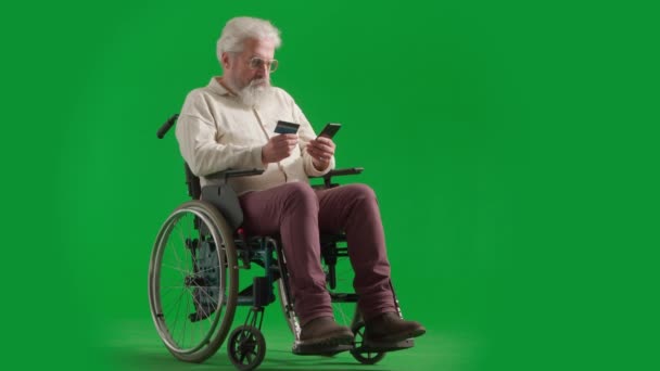 养恤金领取者照料和日常生活创意广告概念 彩色键绿色屏幕上的老年男子画像 坐轮椅的老年人在智能手机中插入卡号 并在网上支付 — 图库视频影像