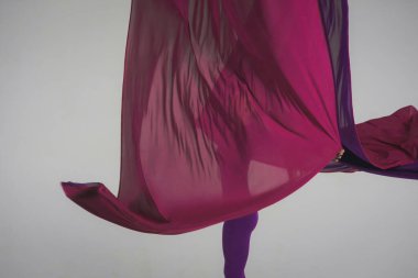 Modern koreografi ve akrobasi yaratıcı reklam konsepti. Stüdyoda beyaz arka planda izole edilmiş kadın akrobatın portresi. Hava ipeğiyle jimnastik yapan kız dansçı..