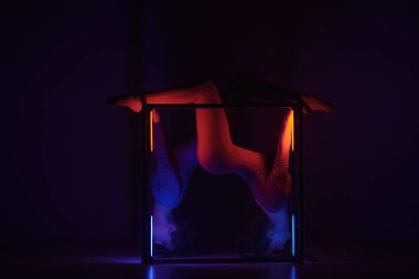 Modern koreografi ve akrobasi yaratıcı reklam konsepti. Siyah arka planda izole edilmiş iki kadın akrobatın portresi. Mavi elbiseli kızlar küp içinde poz veriyorlar..