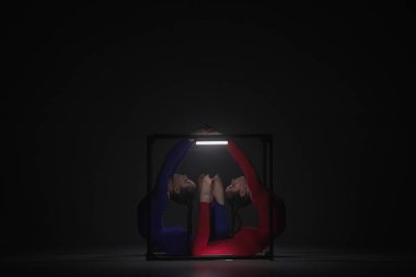 Modern koreografi ve akrobasi yaratıcı reklam konsepti. Siyah arka planda izole edilmiş iki kadın akrobatın portresi. Mavi elbiseli kızlar küp içinde poz veriyorlar..