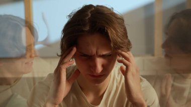 İnsan duyguları yaratıcı reklam konsepti. Odada genç birinin portresi var. Elele tutuşan adam sesler duyuyor, yanlardaki kişilikler çıldırıyor bağıran duygular çıldırıyor. Çift pozlama.