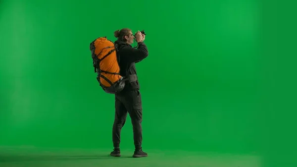 여행자는 하이킹하는 카메라로 사진을 찍습니다 뒷면에 배낭이있는 관광객은 화면의 스튜디오에서 — 스톡 사진