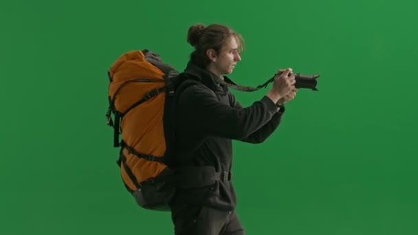 Yürürken Kamerayla Fotoğraf Çeken Bir Erkek Gezginin Yan Görüntüsü Stüdyoda — Stok video