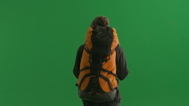背中にバックパックを背負った男性旅行者のリアビュー グリーンスクリーンのスタジオでの男性旅行者 ハイキングトレッキング休暇旅行のコンセプト — ストック動画