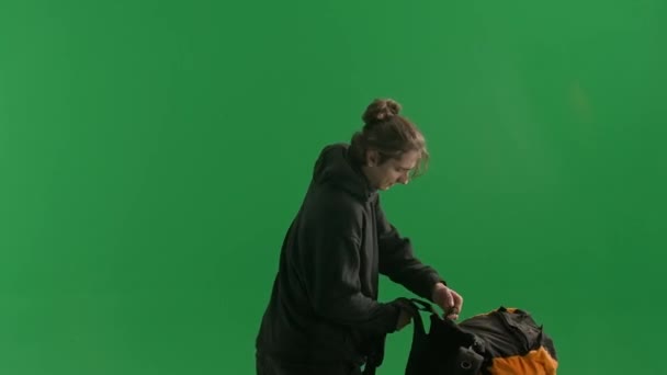 Yeşil Ekranda Bir Stüdyoda Sırtından Bir Sırt Çantası Çıkaran Bir — Stok video