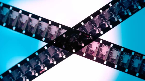 Crossed stripes of photographic film on blue background close up. Negatives of photographic film showing animals, cows, close up