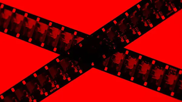 Crossed stripes of photographic film on red background close up. Negatives of photographic film showing animals, cows, close up