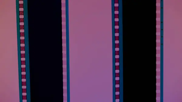 Two vertical film strips on a pink background, close up. 35mm film slide frame. Long, retro film strip frame. Copy space
