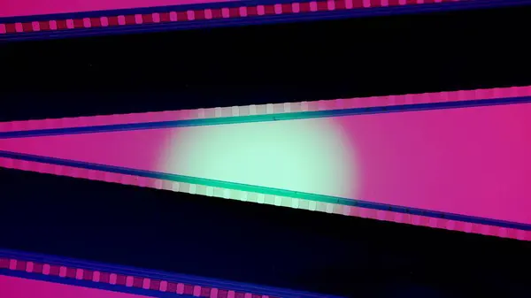 Två Svarta Filmremsor Rosa Bakgrund Belysta Med Grönt Cirkulärt Ljus — Stockfoto